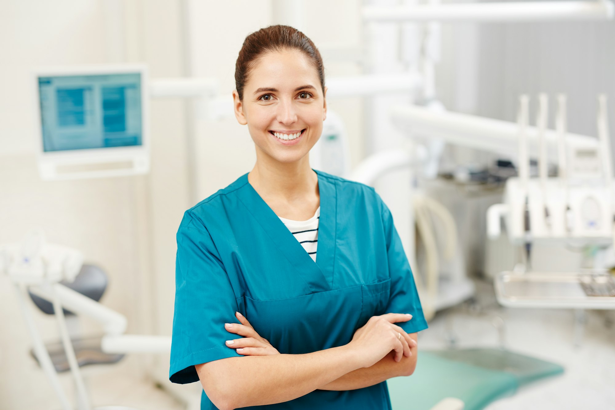 Carer in blue scrubs smiling